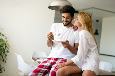 Cute young cheerful couple spending time at homeの写真素材