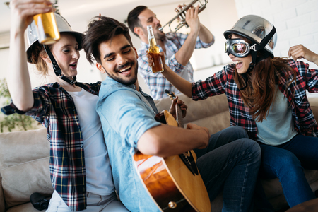 Cheerful friends having party together and playing instrumentsの写真素材