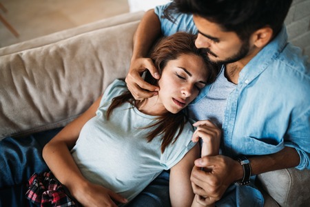 Pretty young girl lying on lap of her boyfriend