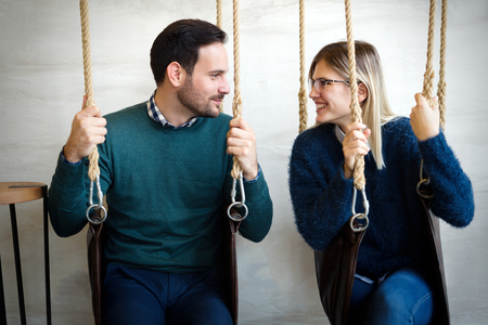 Beautiful young loving couple relaxing in swingの写真素材