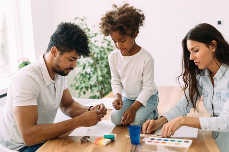 Mother and father drawing together with their childの写真素材
