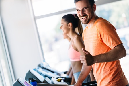 Group of friends exercising on treadmill machineの写真素材