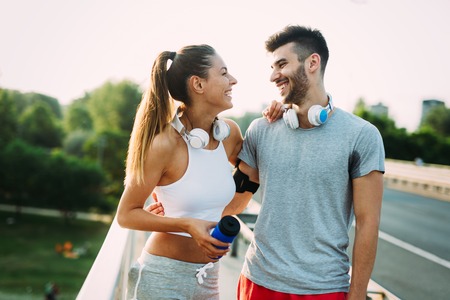 Portrait of man and woman during break of joggingの写真素材