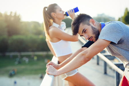 Portrait of man and woman during break of joggingの写真素材