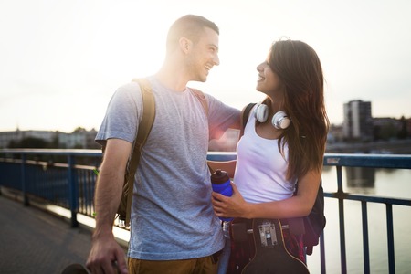 Picture of young attractive couple carrying skateboardsの写真素材
