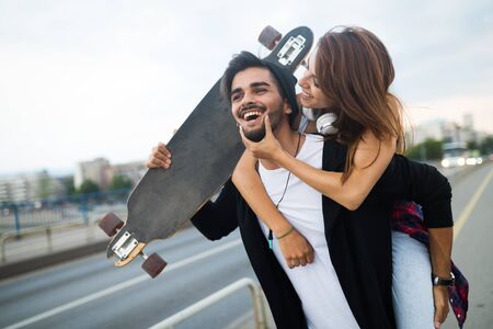 Picture of young attractive couple carrying skateboardsの写真素材