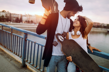 Picture of young attractive couple carrying skateboardsの写真素材