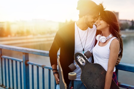 Picture of young attractive couple carrying skateboardsの写真素材