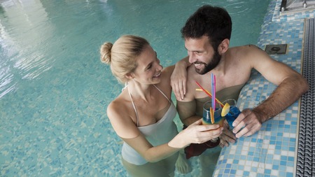 Cheerful happy couple relaxing in swimming pool