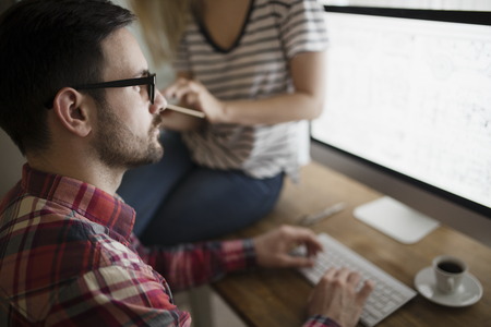 Beautiful woman and attractive man doing design workの写真素材