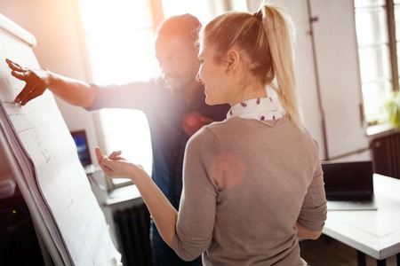 Young handsome designer presenting his work to female colleagueの写真素材