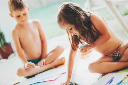 Little boy and girl drawing with crayonsの写真素材