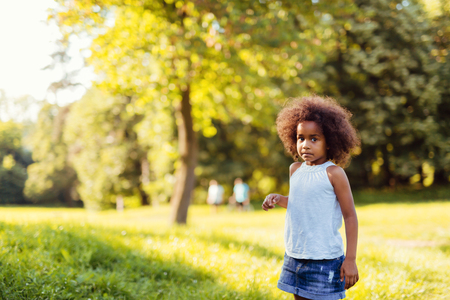 Portrait of little girl standing and looking confusedの写真素材