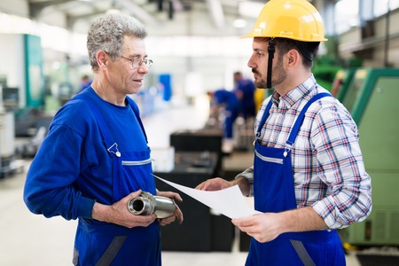 Team Of Engineers Having Discussion In Factoryの写真素材
