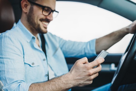 man using phone while driving the carの写真素材