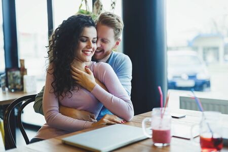 Young happy couple on date in coffee shopの写真素材