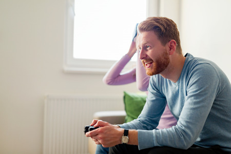 Happy young couple playing video games with virtual reality headsetsの写真素材
