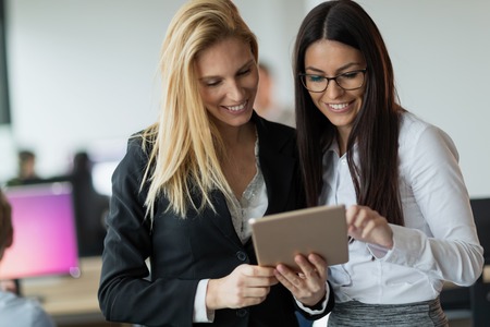 Attractive businesswomen using digital tablet in officeの写真素材