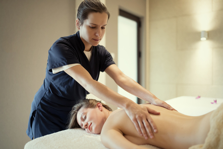 Masseur massaging masseuse at wellness resortの写真素材
