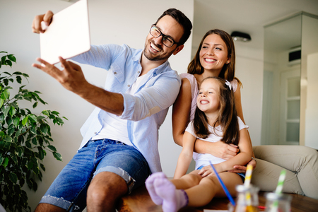 Happy family taking selfie in their houseの写真素材