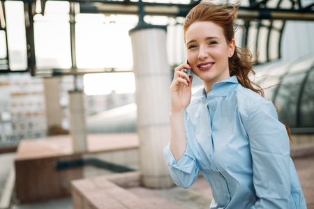 Portrait of businesswoman walking and talking on phoneの写真素材