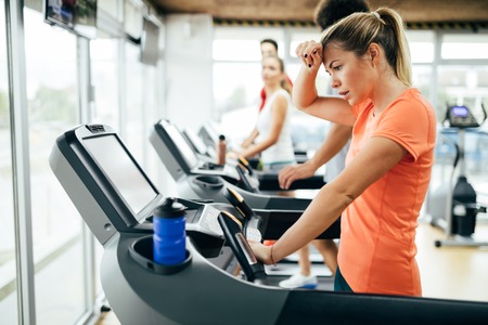 Young attractive woman doing cardio training in gym