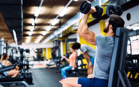 Young handsome man doing exercises in gymの写真素材