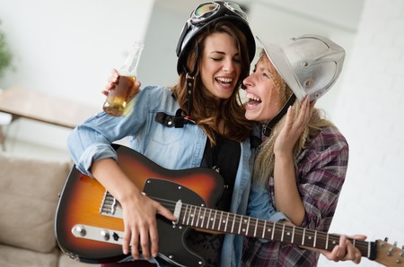 Young happy dancing girls playing guitar and partyingの写真素材