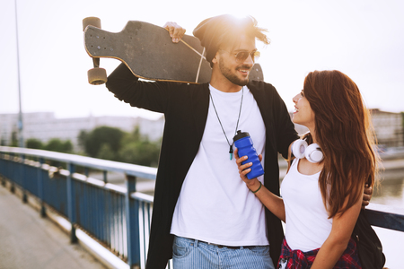 Picture of young attractive couple carrying skateboardsの写真素材