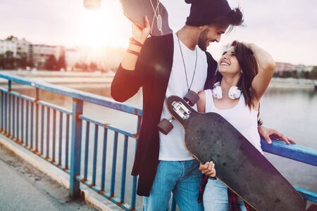 Picture of young attractive couple carrying skateboardsの写真素材