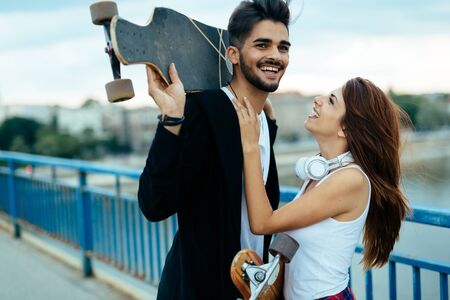 Picture of young attractive couple carrying skateboardsの写真素材
