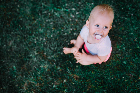 Portrait of lovely baby sitting on lawn