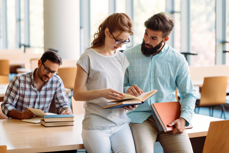 Young attractive students spending time in libraryの写真素材