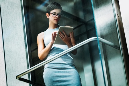 Portrait of attractive young businesswoman using tablet