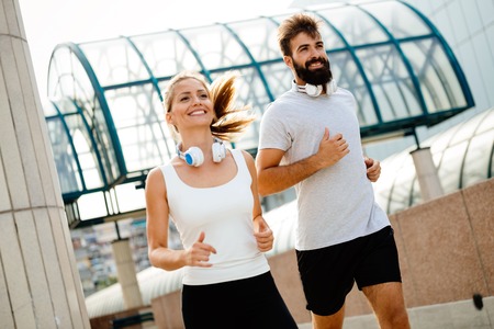 Young fitness couple running in urban areaの写真素材