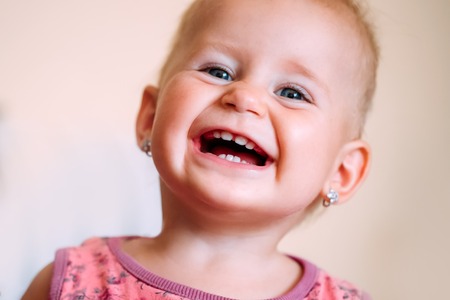 Portrait of playful cute little baby girlの写真素材