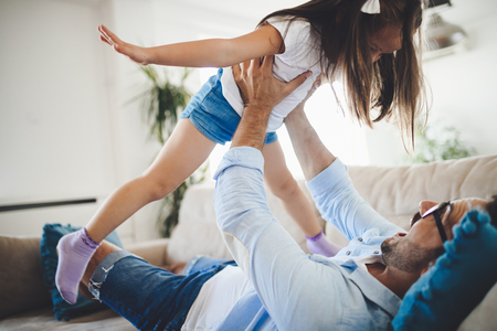 Portrait of father and daughter playing at homeの写真素材