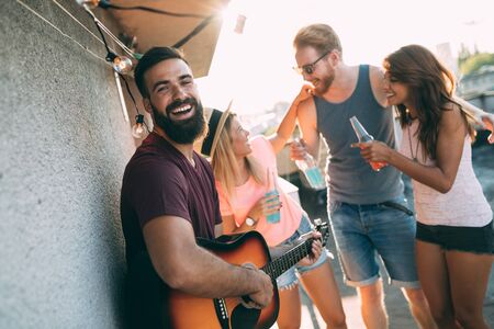 Group of happy friends having party on rooftopの写真素材