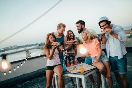 Group of happy friends having party on rooftopの写真素材