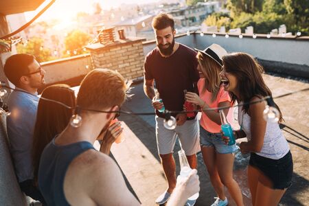 Group of happy friends having party on rooftop