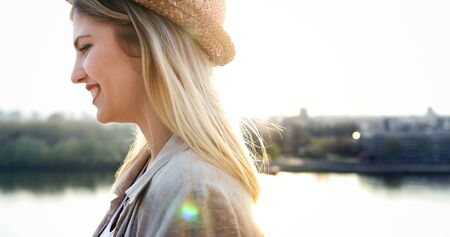 Happy blond female wearing hat outdoorの写真素材