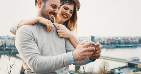 Happy couple having fun and taking a selfieの写真素材