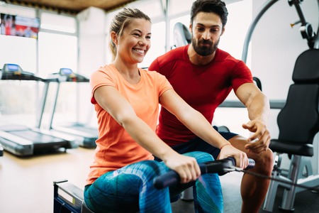 Young beautiful woman doing exercises with personal trainer