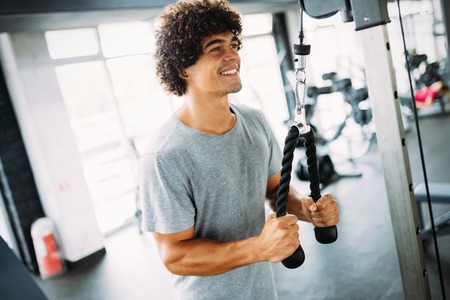 Young handsome man doing exercises in gymの写真素材