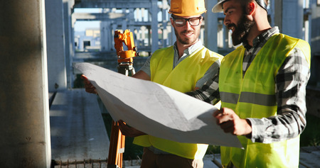 Team of construction engineers working on building siteの写真素材