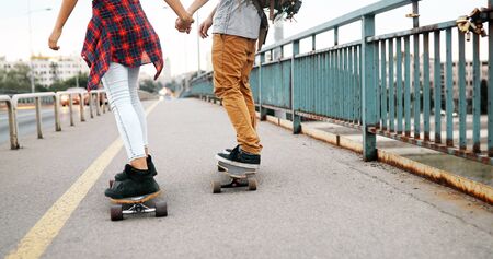 Picture of young attractive couple carrying skateboardsの写真素材