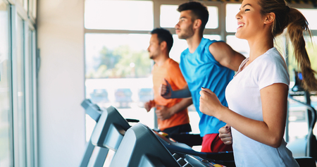 Group of friends exercising on treadmill machineの写真素材
