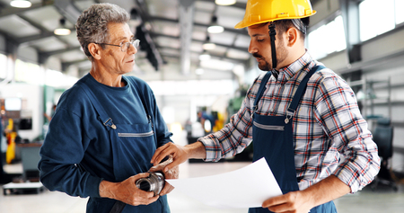 Supplier with engineer checking on production in factoryの写真素材