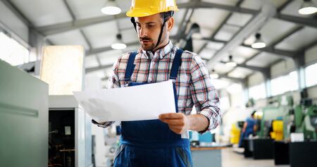 Portrait of an architect builder studying layout plans of plantの写真素材