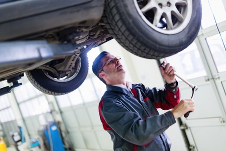 Car mechanic working at automotive service centerの写真素材